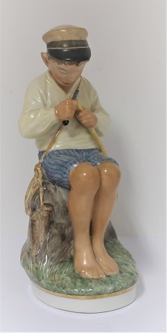 Royal Copenhagen. Porcelænsfigur. Siddende dreng i farver. Model 905. Højde 19 
cm. (1 sortering)