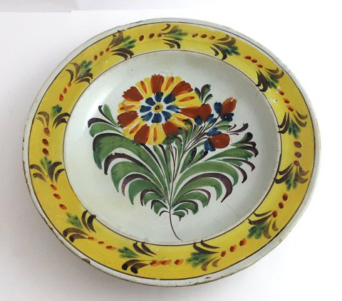 Kellinghusen tallerken, fajance. Dyb tallerken med blomstermotiv. Diameter 23 
cm. Med reparation.